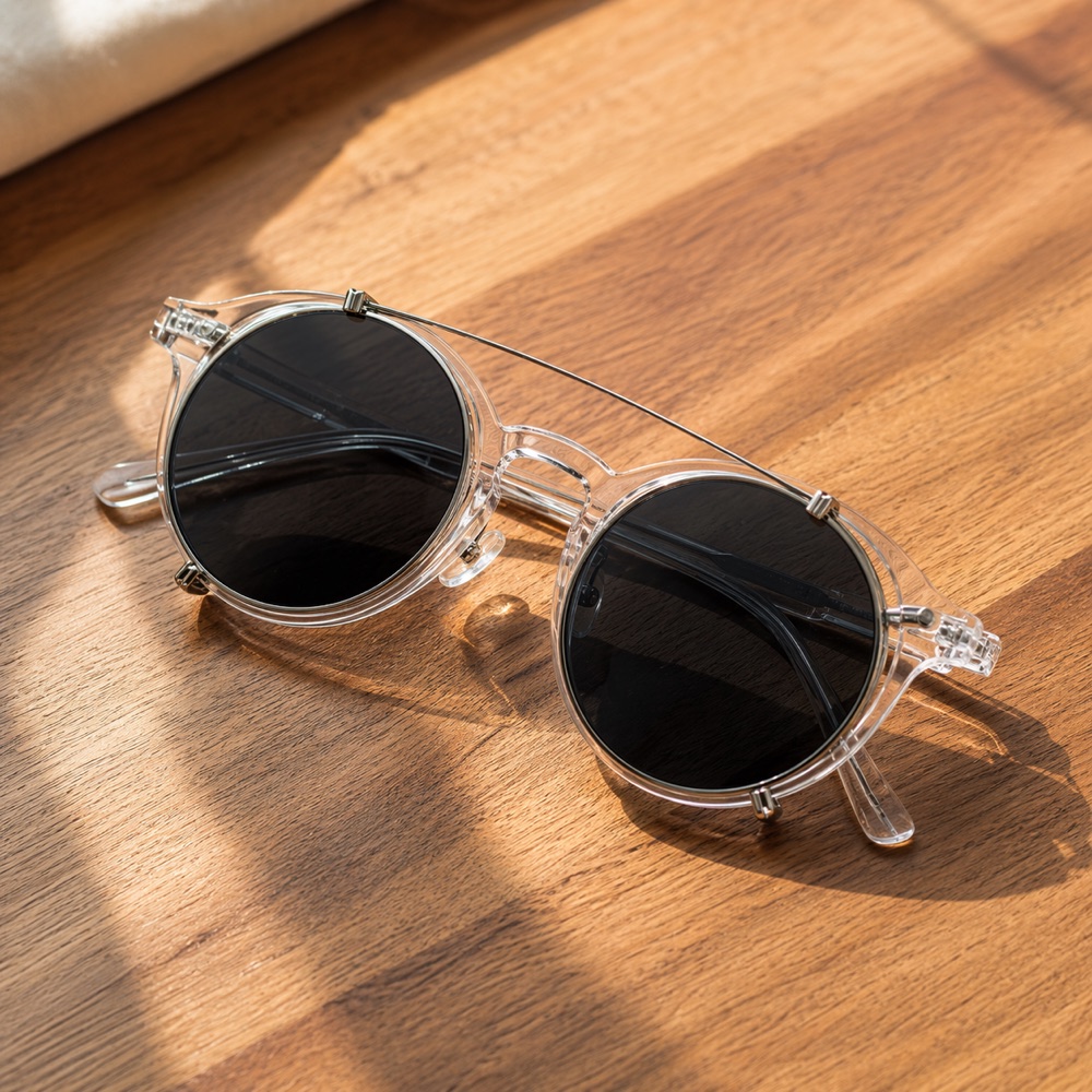 Gafas Aurora Flex transparentes con clip solar polarizado sobre mesa de madera